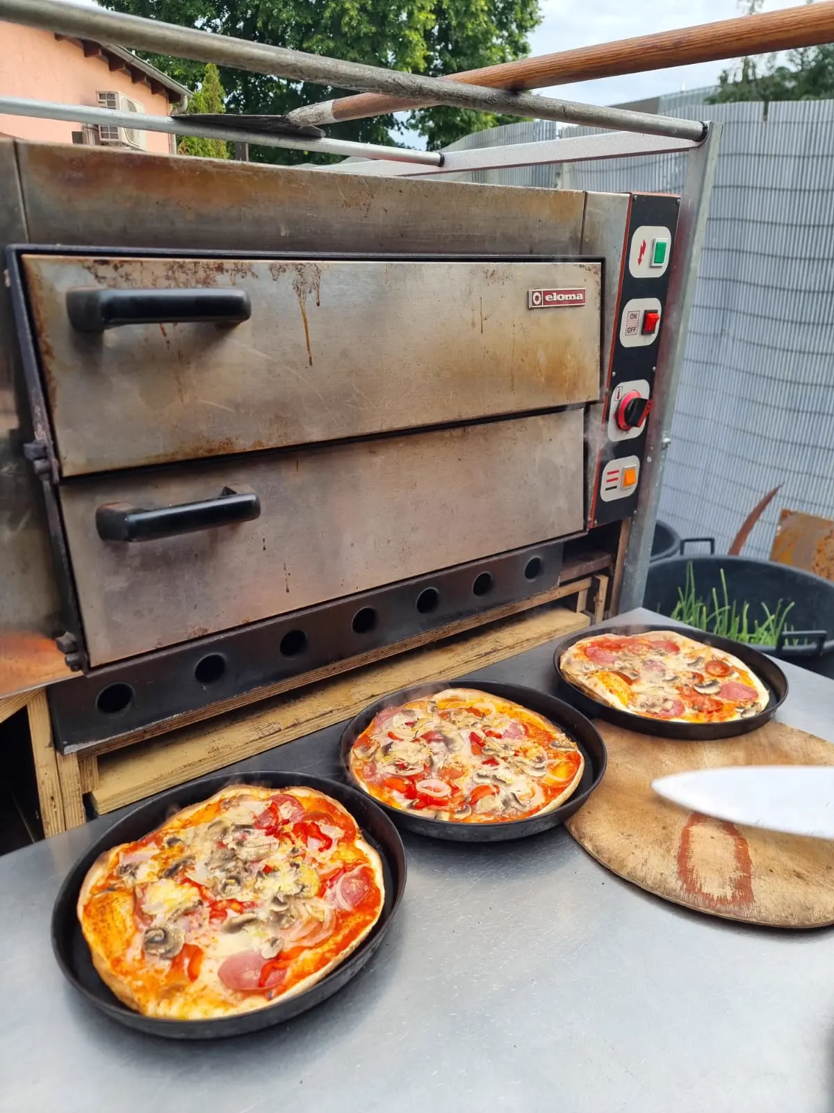 Mehrere Pizzen vor dem Ofen in der Vorbereitung