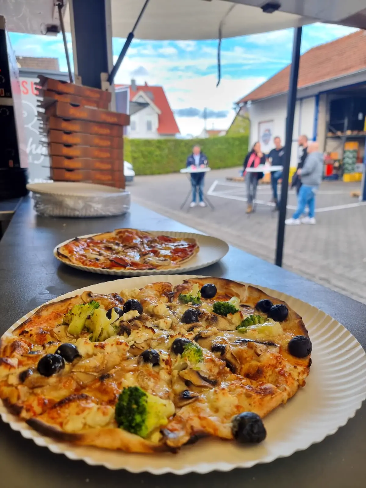 Frische Pizza auf dem Tisch vor dem Catering-Anhänger
