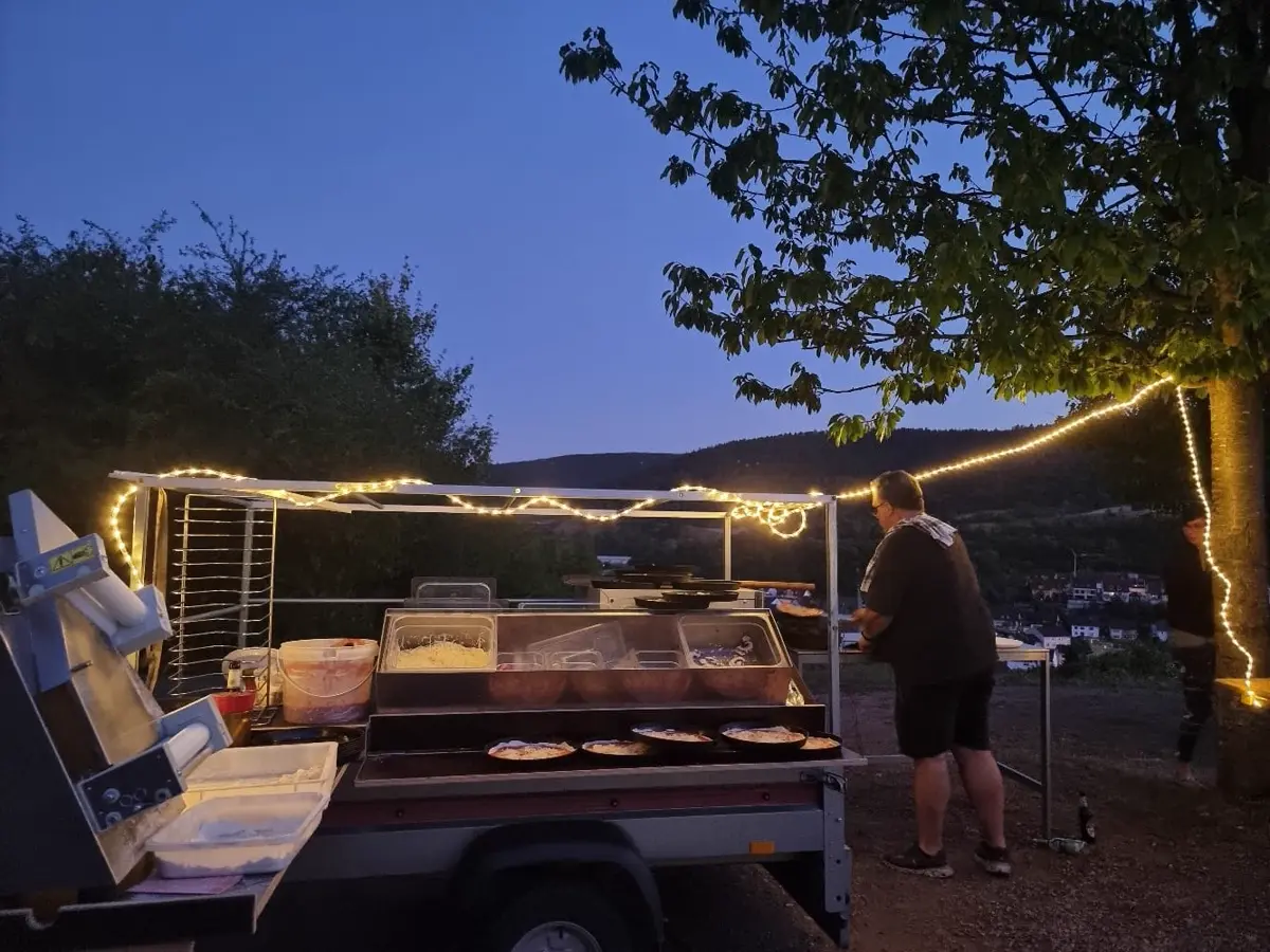 Pizza-Anhänger mit Lichterkette am Abend