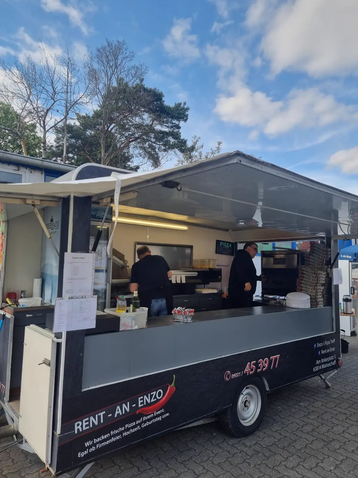 Pizza-Anhänger neben einem weißen Pavillon