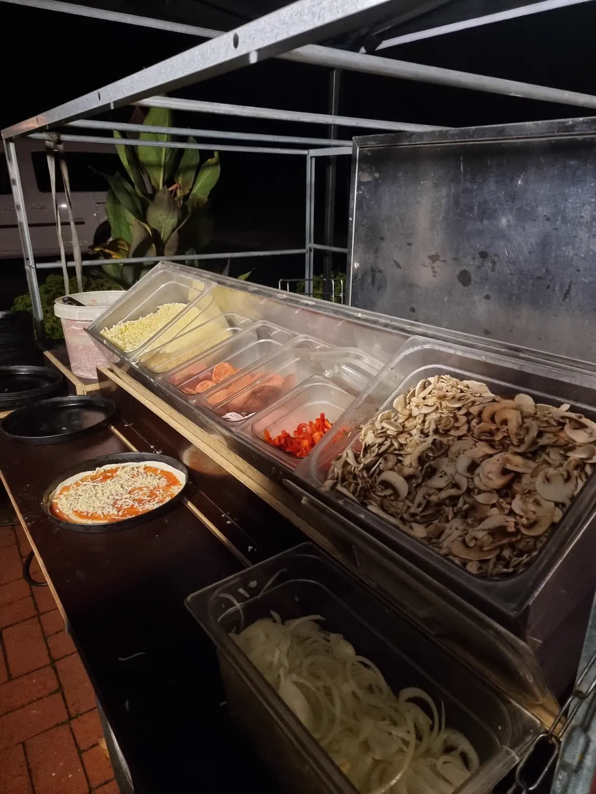 Zutatenstation mit frischen Belägen für Pizza im Freien